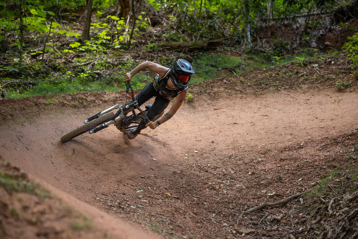 Rider carving a dirt berm on the Invert Enduro fork