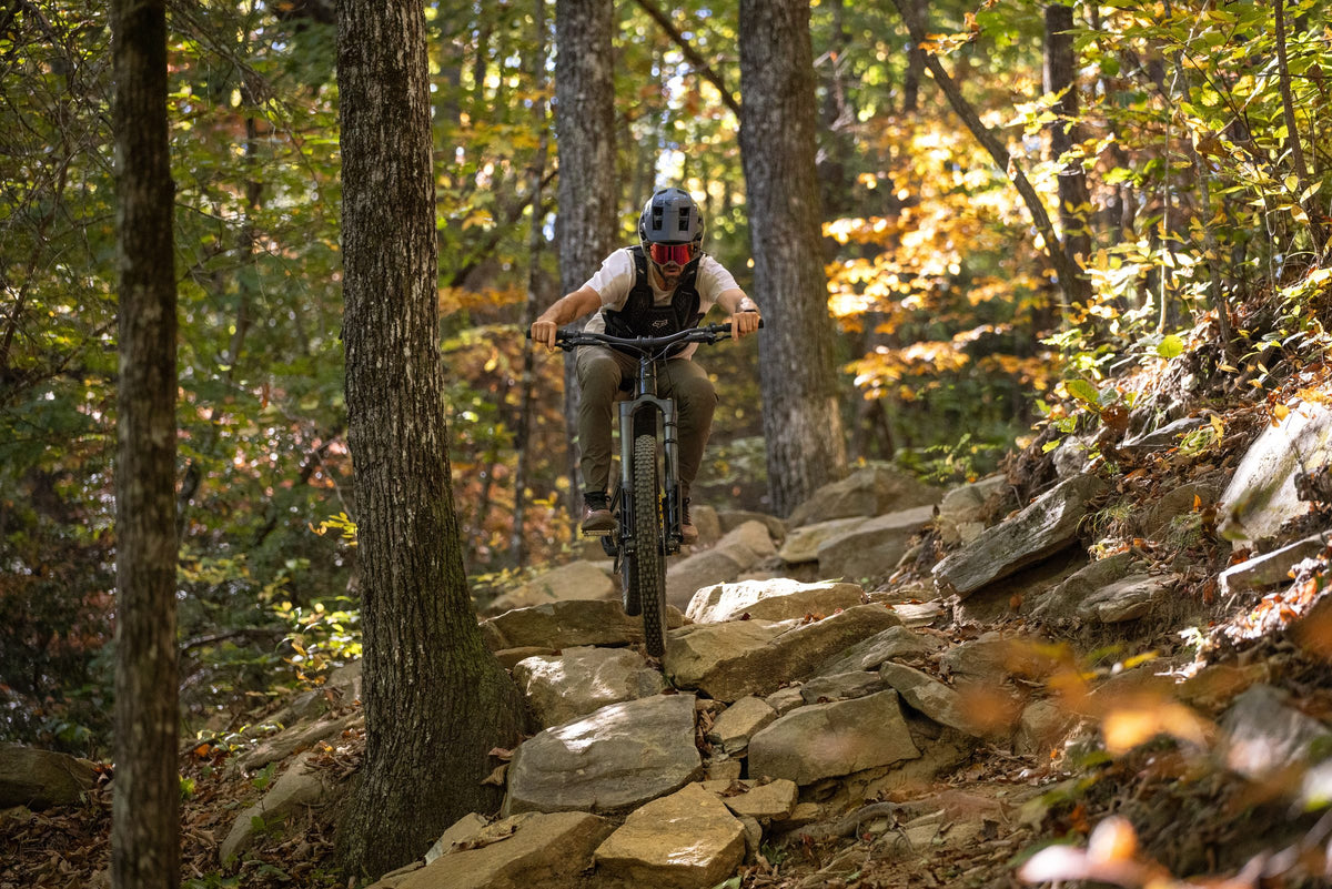 Rider descending autumn rock steps on the Invert Enduro